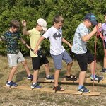 czterech uczniów próbuje iść na deskach przymocowanych do stóp
