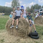 uczniowie wchodzą po oponach na snop siana