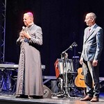 Arcybiskup przemawia na scenie.