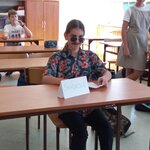 Zdjęcie przedstawia uczennicę grającą rolę świadka w inscenizowanej rozprawie sądowej.