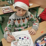 Chłopiec maluje bombkę brokatem