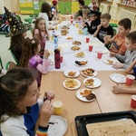 dzieci przy stole ze smkołykami.