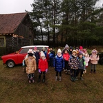 Dzieci pozują do zdjęcia przy czerwonym samochodzie.