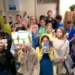 Uczniowie pozują do zdjęcia. Prezentują swoje nagrody oraz książki.