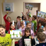Uczniowie pozują do zdjęcia. Prezentują swoje nagrody oraz książki.