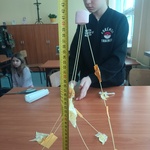Uczniowie miarką mierzą wieżę z makaronu