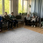 Uczniowie podczas warsztatów. Siedzą na krzesłach w kole.