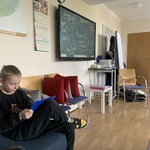 Uczniie podczas warsztatów. Siedzą w kole. Wypełniają karty pracy