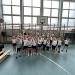 Uczniowie pozują do grupowego zdjęcia z medalami.
