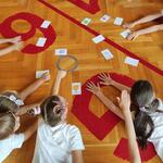 Uczniowie grają w grę na podłodze