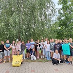 Uczniowie pozują do zdjęcia. Trzymają worki do segregacji śmieci.