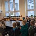 Dzieci słuchają wypowiedzi nauczyciela bibliotekarza