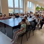 Dzieci słuchają książki czytanej przez bibliotekarza