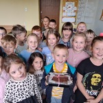 Uczniowie pozują do zdjęcia z ciastem marchewkowo-jabłkowym