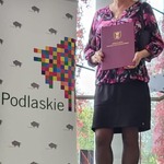 Nauczyciel pozuje do zdjęcia. Prezentuje dyplom.