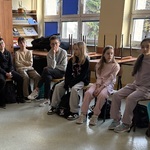 Uczniowie siedzą na krzesłach w okręgu
