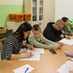 Zdjęcie uczniów i rodziców w trakcie poprawy dyktanda niepodległościowego