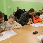 Zdjęcie uczniów i rodziców w trakcie poprawy dyktanda niepodległościowego w szkole