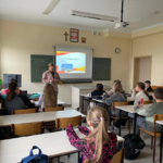 Uczniowie uczestniczą w zajęciach. Siedzą w ławkach.