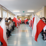 Uczniowie stoją na baczność. Śpiewają hymn