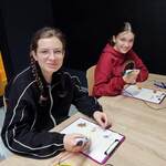 Uczennice wykonują modele długopisem 3D. Siedzą przy stołach