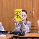Uczennica prezentuje książkę swoim kolegom