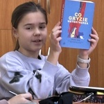 Uczennica prezentuje książkę kolegom z klasy