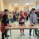 uczniowie stoją przy ławce gotowi do odpowiedzi na pytanie