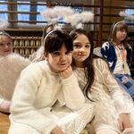 Dwie dziewczynki w strojach aniołków przytulają się i pozują do zdjęcia