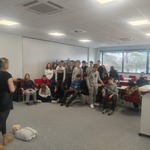 Uczniowie klasy ósmej słuchają pracownika Centrum Powiadamiania Ratunkowego jak należy prawidłowo udzielać pierwszej pomocy