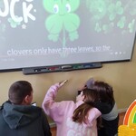 Uczniowie szukają QR kodów, skanują je i zapisują na kartkach odpowiedzi