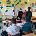 Uczniowie chodzą po klasie. Szukają QR kodów: skanują je i zapisują na kartkach odpowiedzi