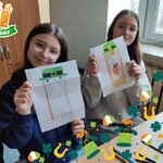 Uczennice pozują do zdjęcia ze swoimi pracami