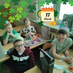 Uczniowie pozują do zdjęcia. Siedzą w ławkach