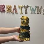 Uczeń w ręku trzyma rzeźbę wykonaną z odpadów