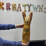 Uczeń w ręku trzyma rzeźbę wykonaną z odpadów