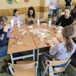Dzieci z rodzicami ozdabiają świece