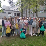 Uczniowie pozują do zdjęcia z workami do segregacji śmieci.