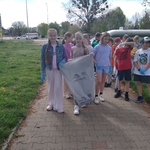 Uczniowie zbierają śmieci. Wrzucają je do odpowiednich worków.