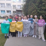 Uczniowie pozują do zdjęcia z workami do segregacji śmieci.
