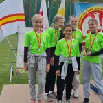 Uczennice stoją na podium. Pozują do zdjęcia.
