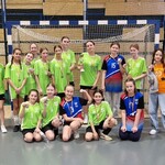 Uczennice pozują do zdjęcia z medalami i pucharem