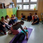 Uczennica układa koleżankę w pozycji bocznej bezpiecznej. Reszta uczniów obserwuje