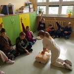 Uczeń wykonuje ucisk klatki piersiowej na fantomie 