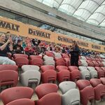 Uczniowie z opiekunami siedza na trybunach stadionu