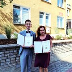 Uczeń i nauczyciel pozują do zdjęcia. Prezentują otrzymane dyplomy.