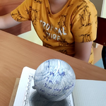 Uczeń pozuje do zdjęcia z ozdobioną kropką