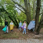 Uczniowie pozują di zdjęcia. Trzymają worki do segregacji odpadów.