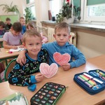 Uczniowie pozują do zdjęcia z wyciętymi i pomalowanymi przez siebie sercami.
