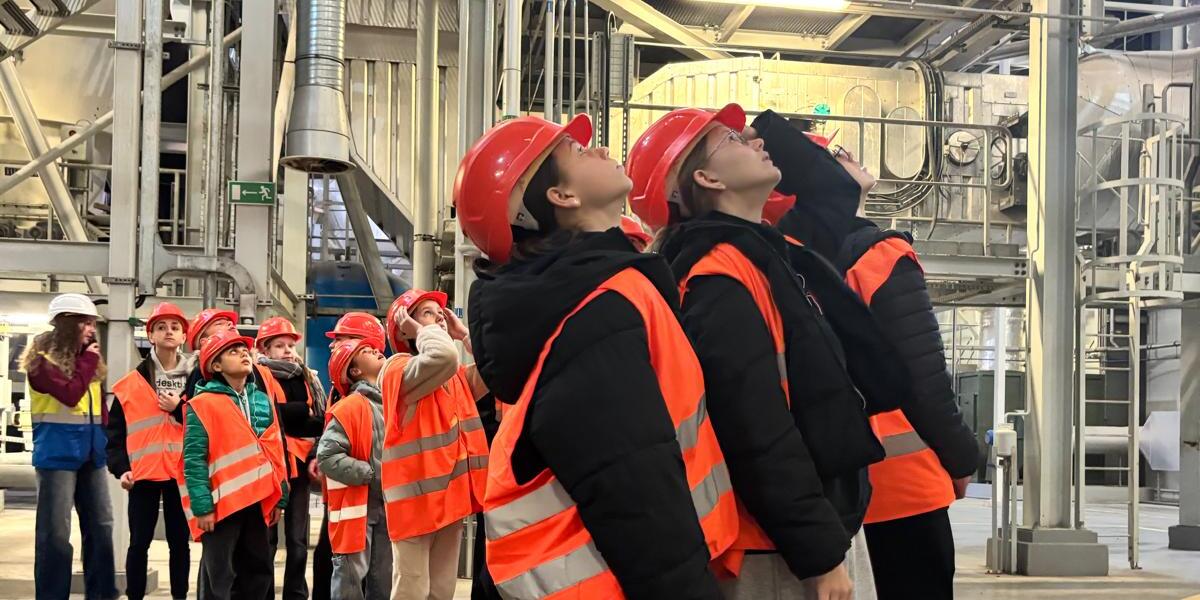 Uczniowie zwiedzają Zakład Unieszkodliwiania Odpadów. Są ubrani w odblaskowe kamizelki i kaski. (1).jpg